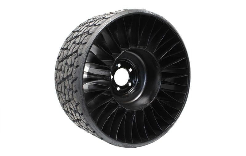 A close up of a black tire on a white background.