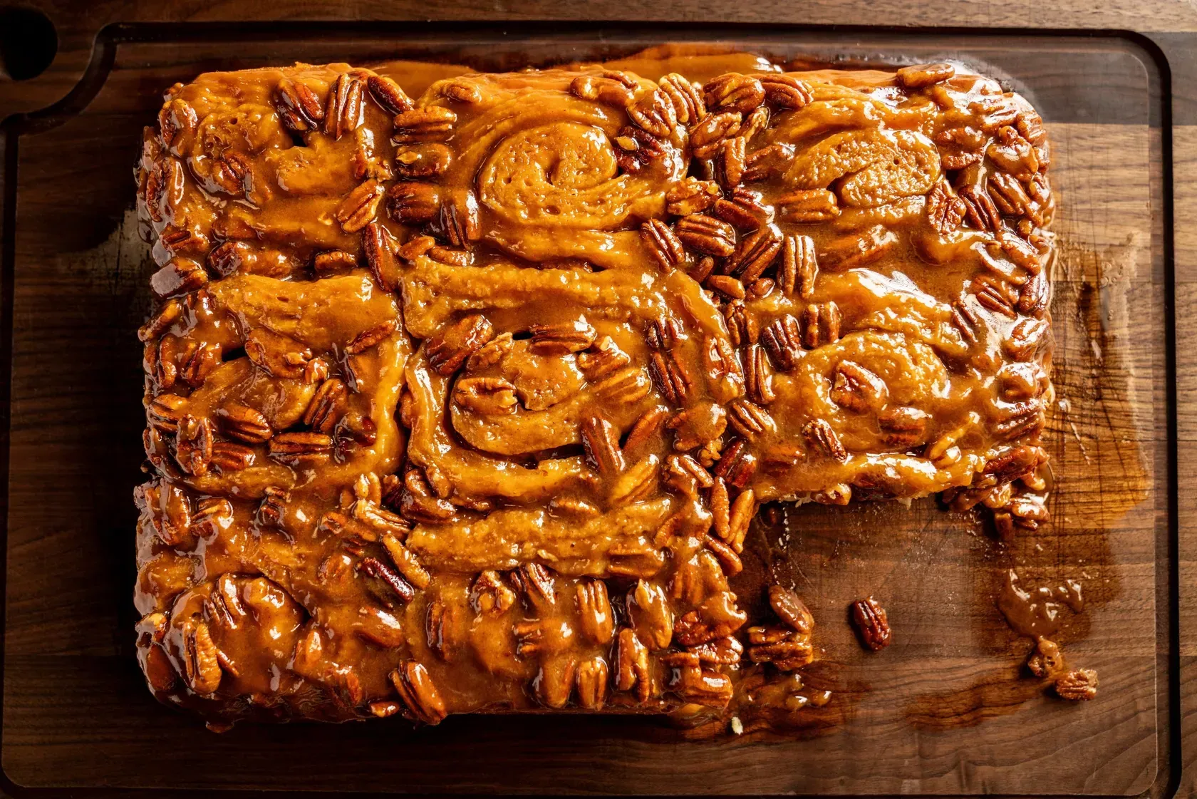 A piece of cake is sitting on top of a wooden cutting board.