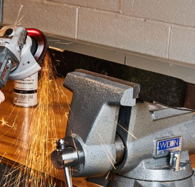A wdn vise is being used to grind a piece of metal