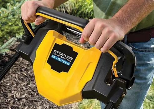 a man is holding the handled of a cub cadet push mower