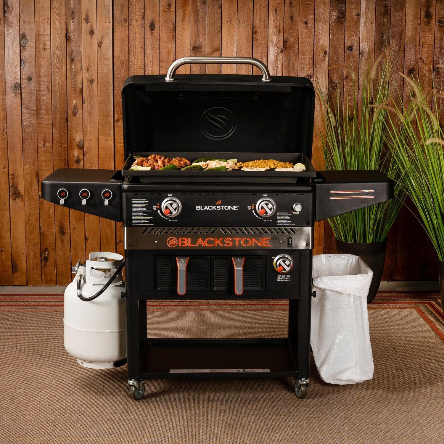 A blackstone grill is sitting on a rug in front of a wooden wall.