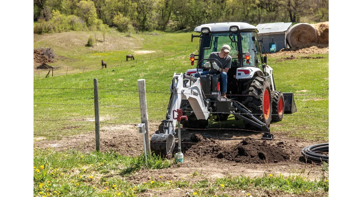 a man is driving a bobcat tractor in a field