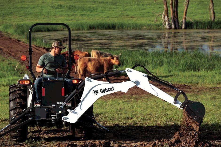 a man is driving a bobcat tractor in a park