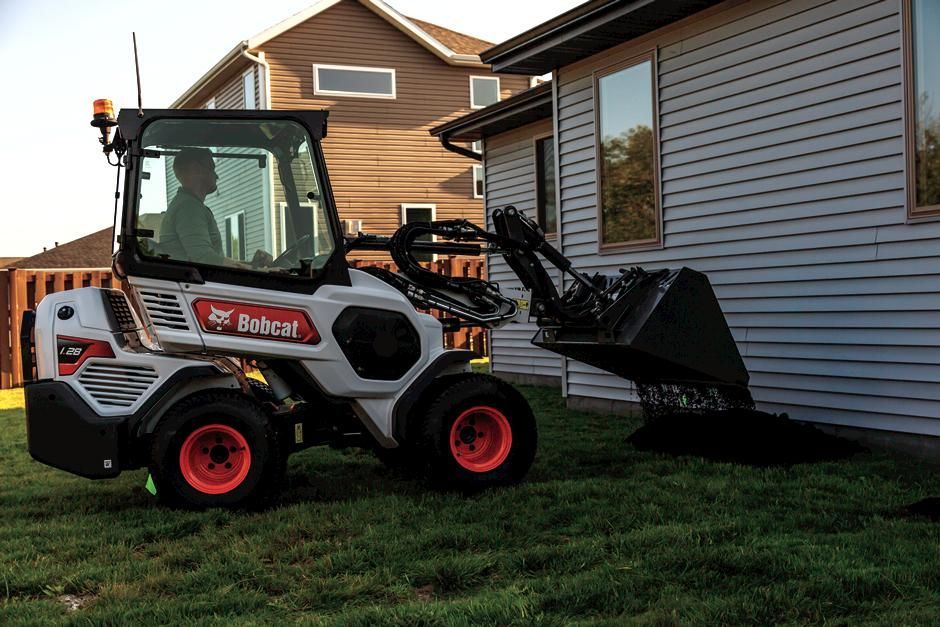 Un tractor Bobcat está estacionado frente a una casa.