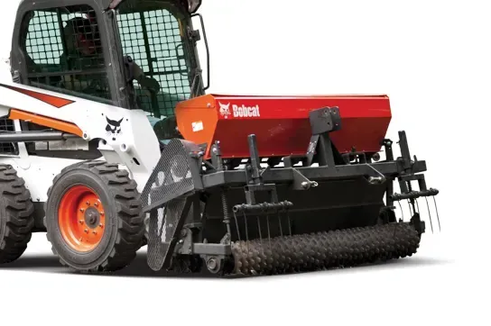 a bobcat tractor with a spreader attached to it