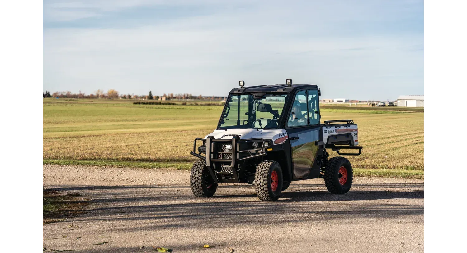 a man is driving a bobcat tractor carrying logs