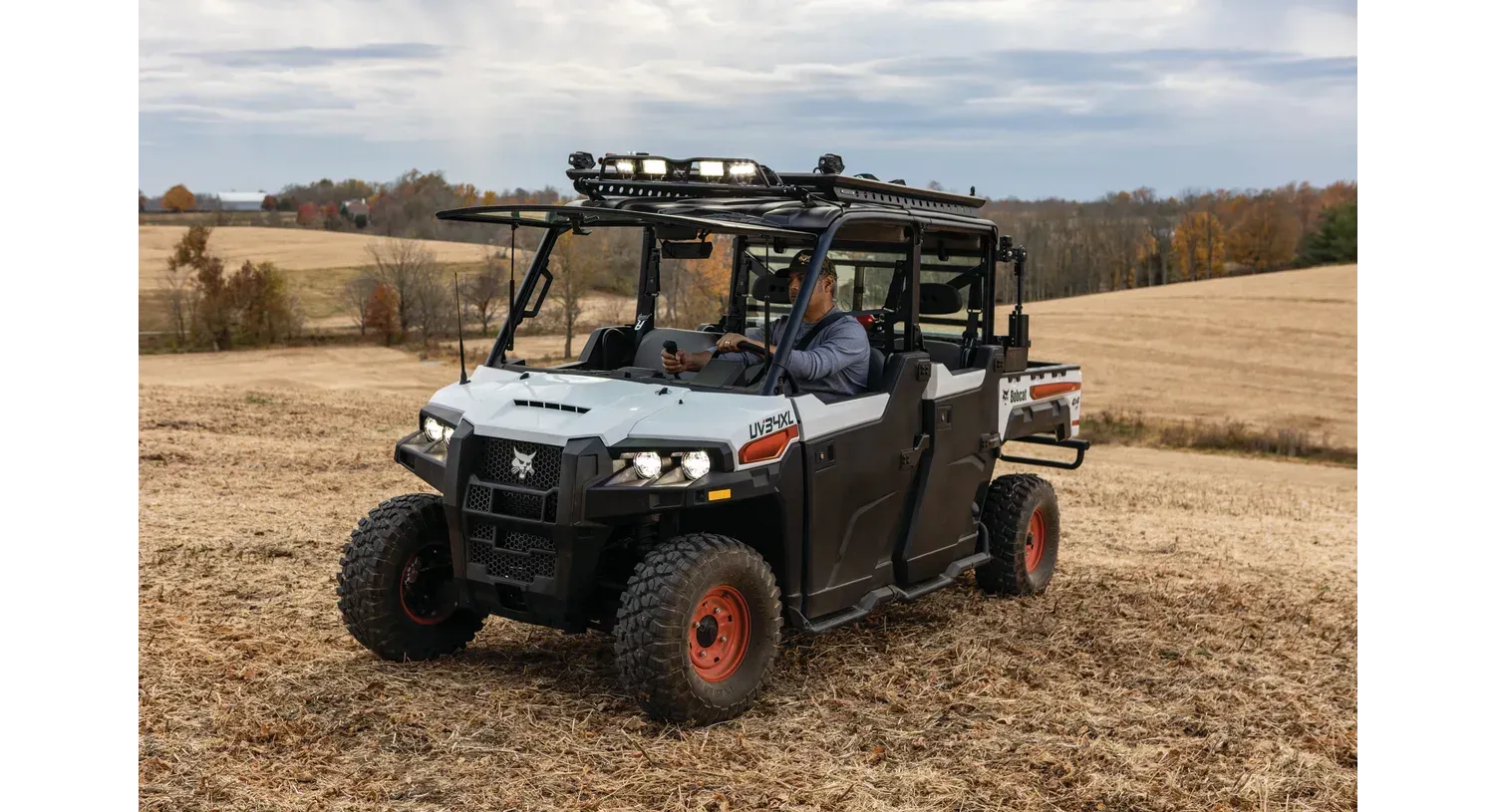 a man is driving a utility vehicle in a field .
