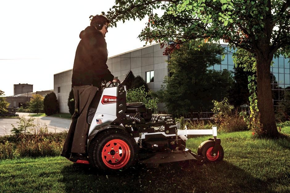 a man is driving a bobcat tractor carrying logs
