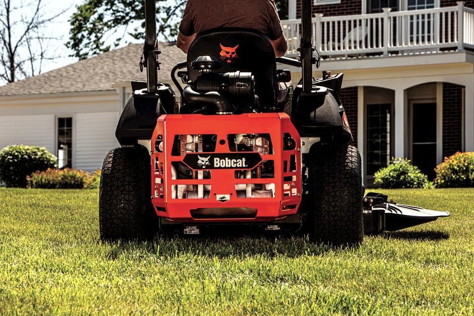 a man is driving a bobcat tractor in a park