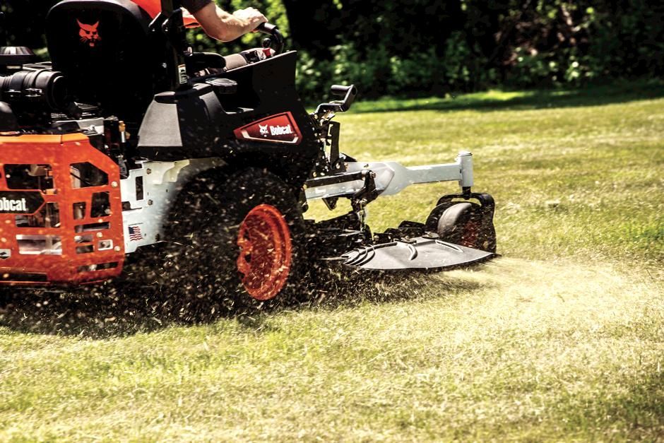 a man is driving a bobcat tractor carrying logs