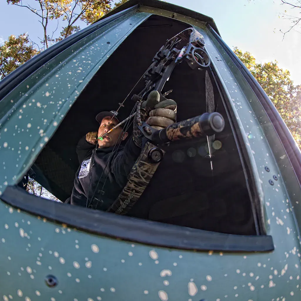 image of a guy in a redneck blind with a bow