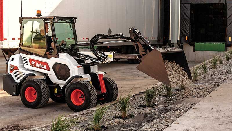 a bobcat tractor is loading rocks into a bucket
