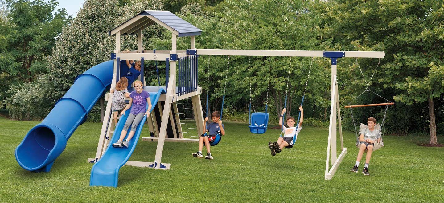 a group of children are playing on a playground with a blue slide and swings
