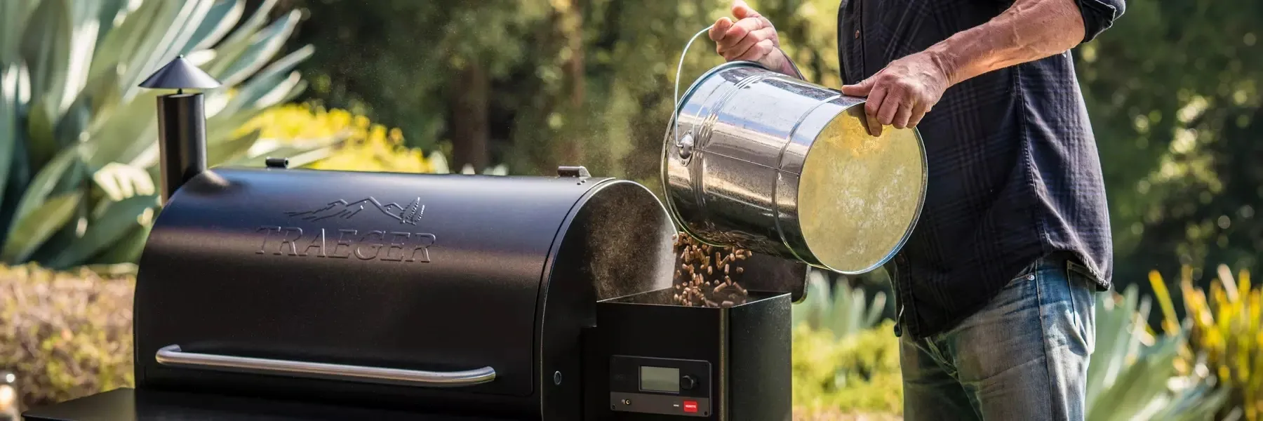 A man is pouring wood into a wood stove.