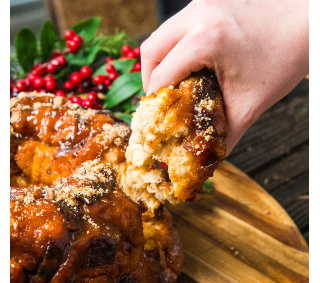 A person is taking a bite out of a monkey bread