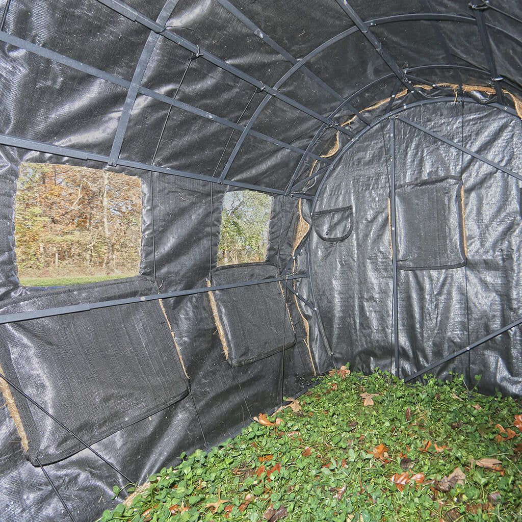 A black tent with a lot of green plants inside of it