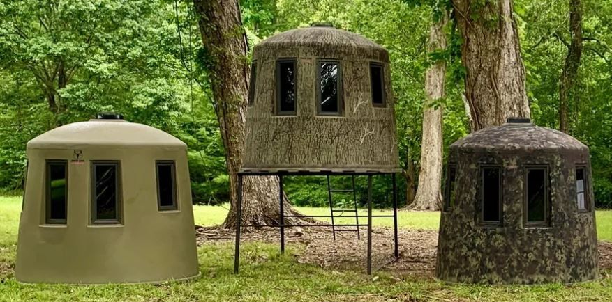 three different types of deer blinds  are sitting next to each other in a field .