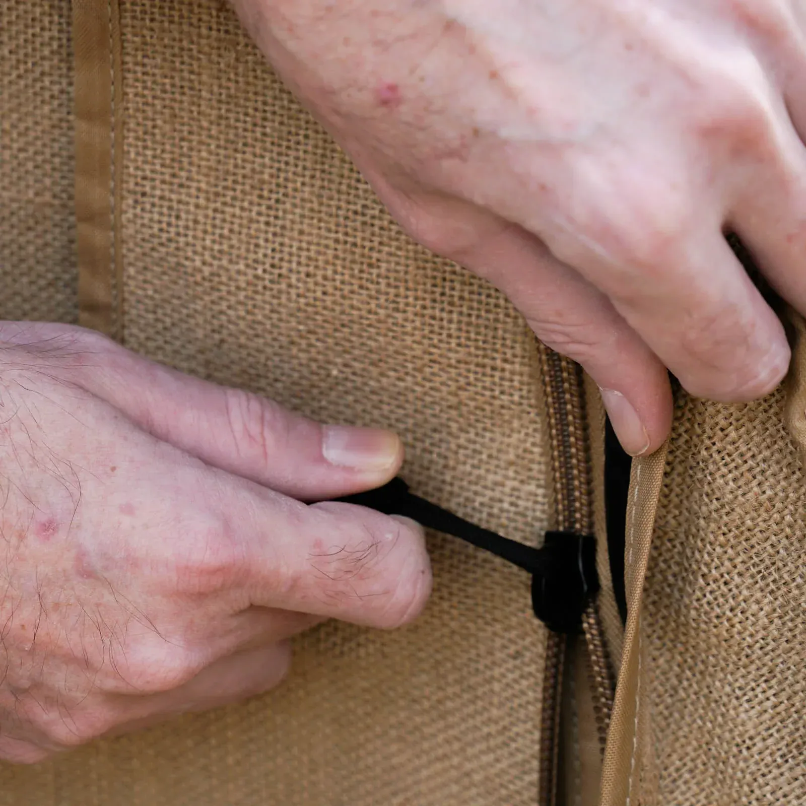 A close up of a person 's hands holding a zipper