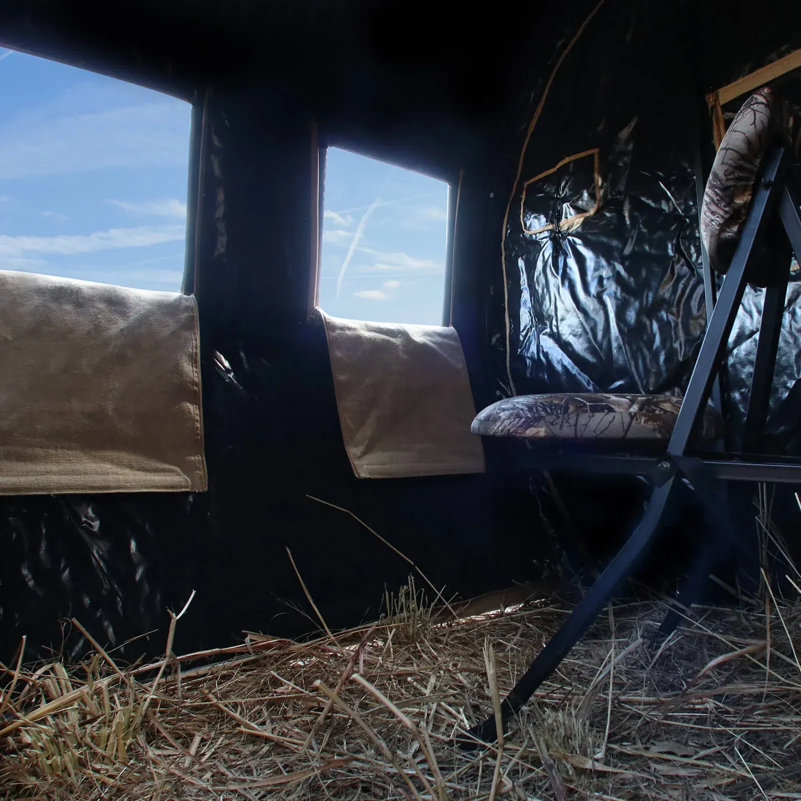 A chair in a dark room with a blue sky in the background