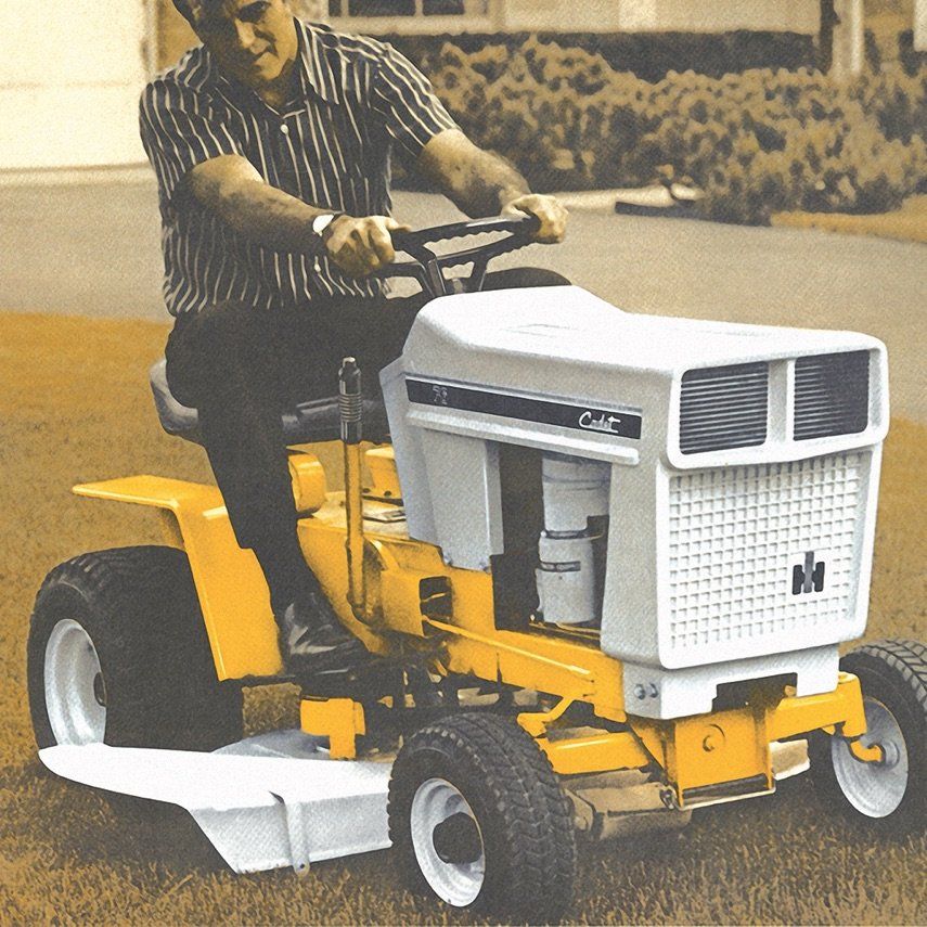 a man is riding a cub cadet tractor style mower