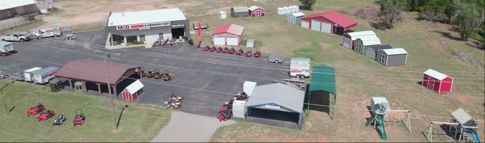 An aerial view of a M&D Enterprises lot with a lot of buildings and carports.