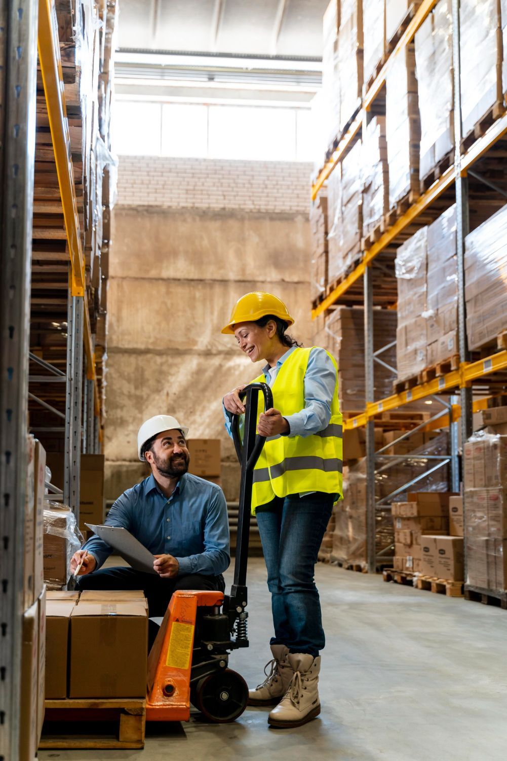 A man and a woman are walking through a warehouse.