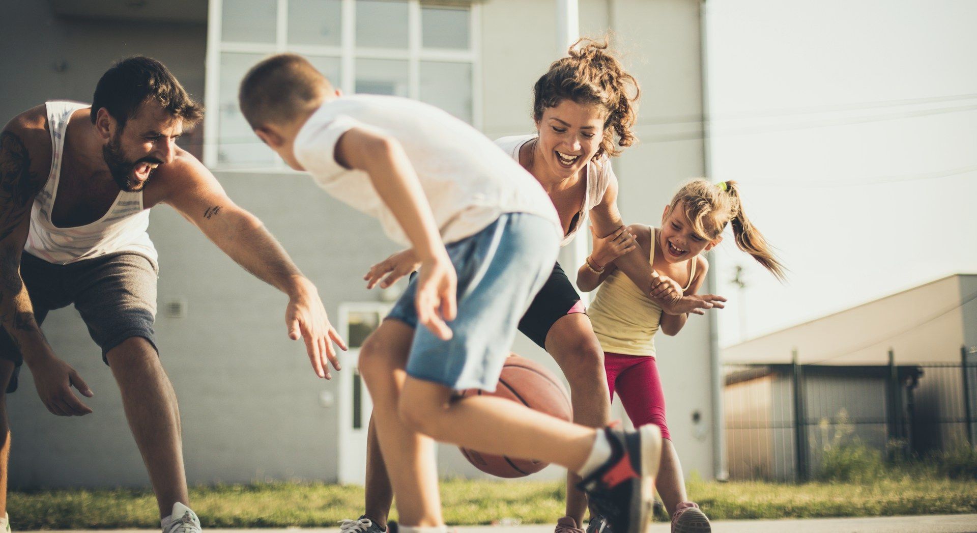 A family is playing basketball together on a court.