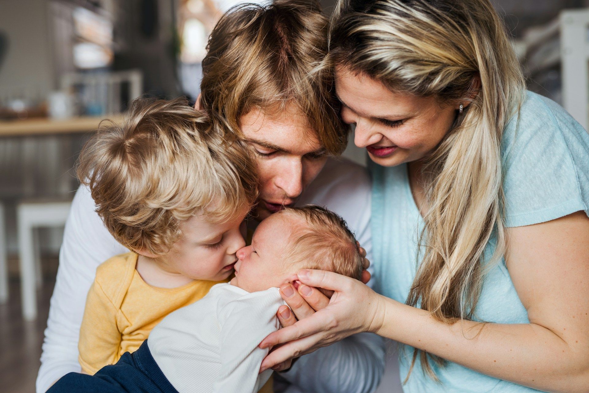 A family is holding a newborn baby in their arms.
