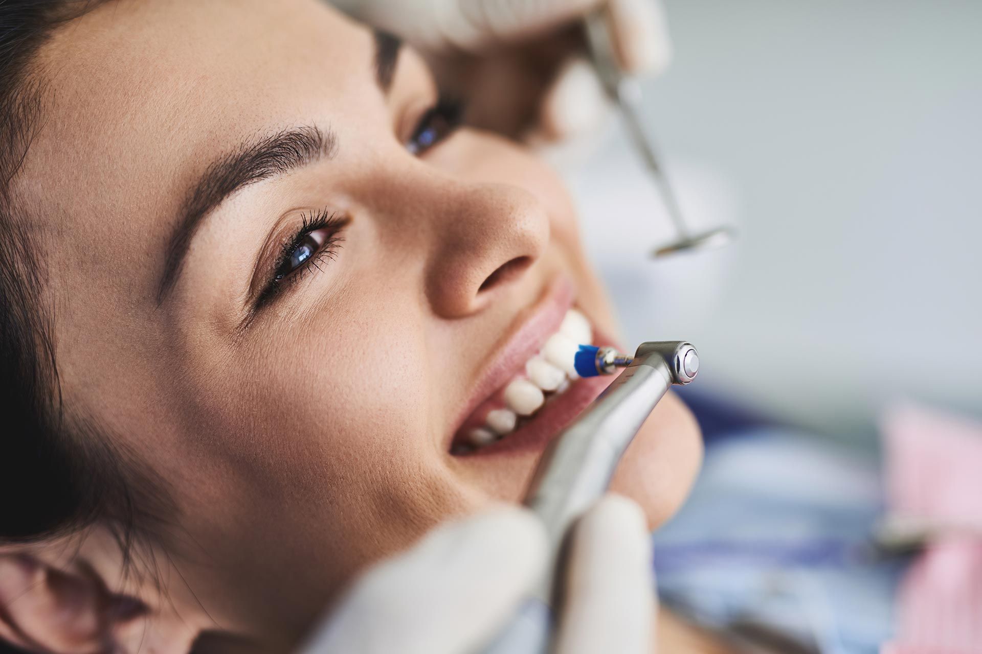 Charming young lady receiving teeth cleaning and polishing at clinic. Charming young lady receiving teeth cleaning and polishing at clinic.