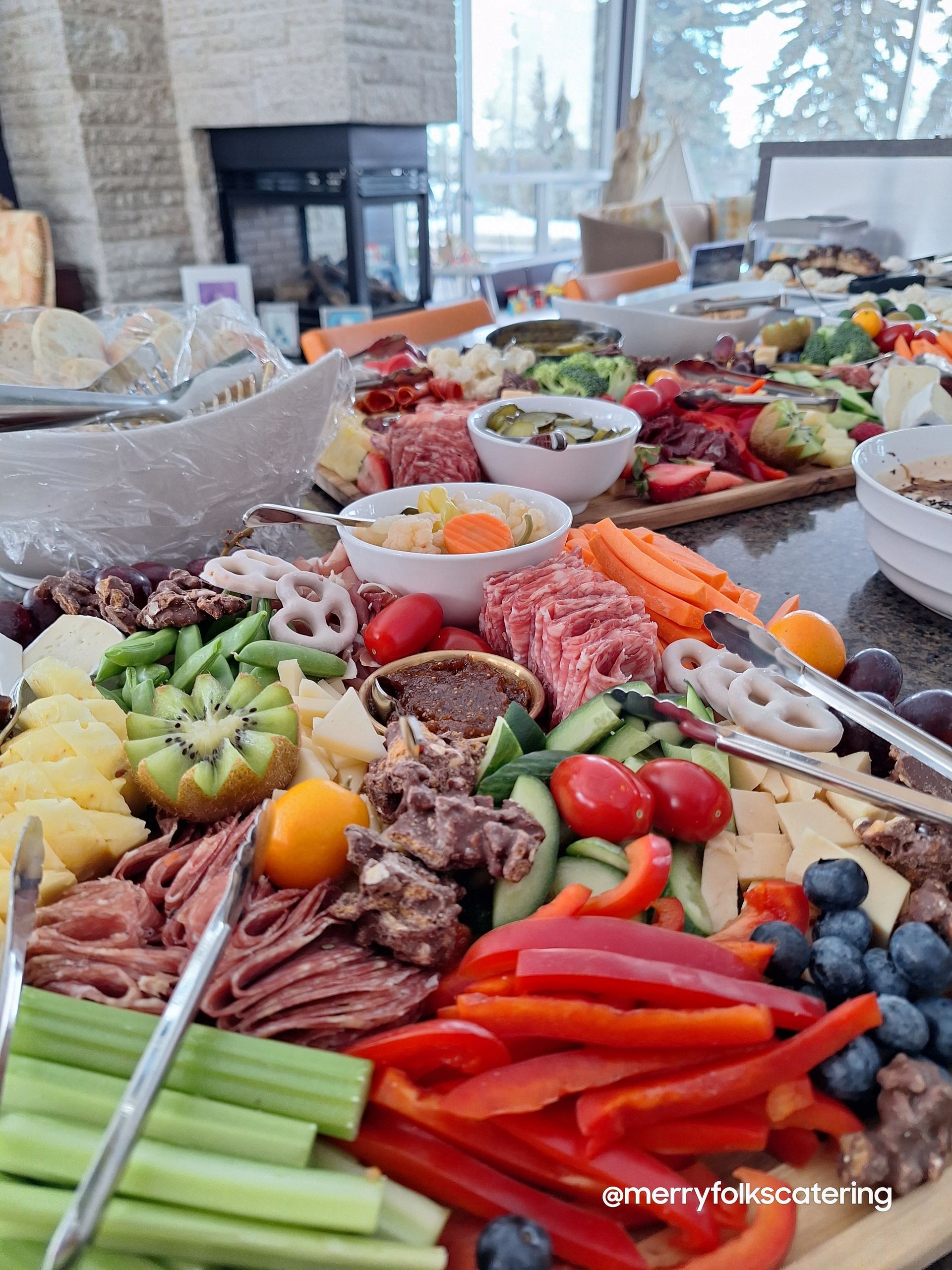 A vibrant charcuterie board with various meats, cheeses, vegetables, and fruits.
