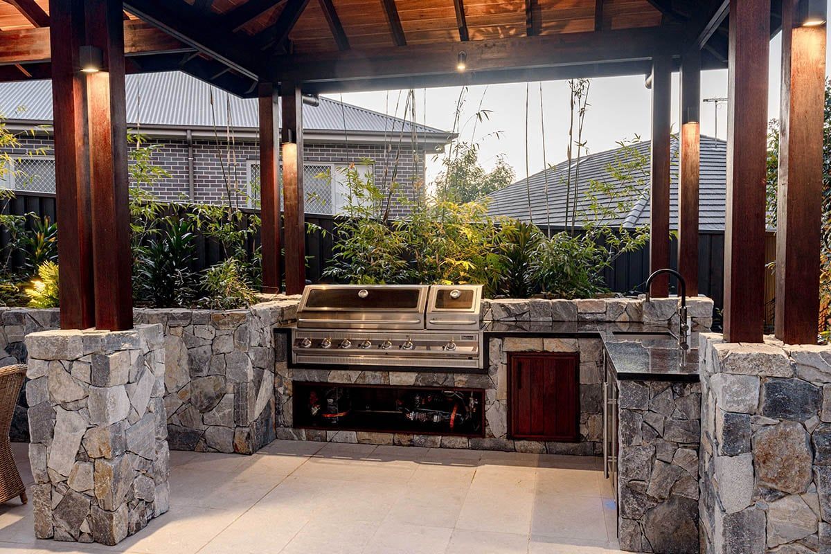 Wooden gate with pathway flanked by greenery, brown wood, grey stone, and gravel.