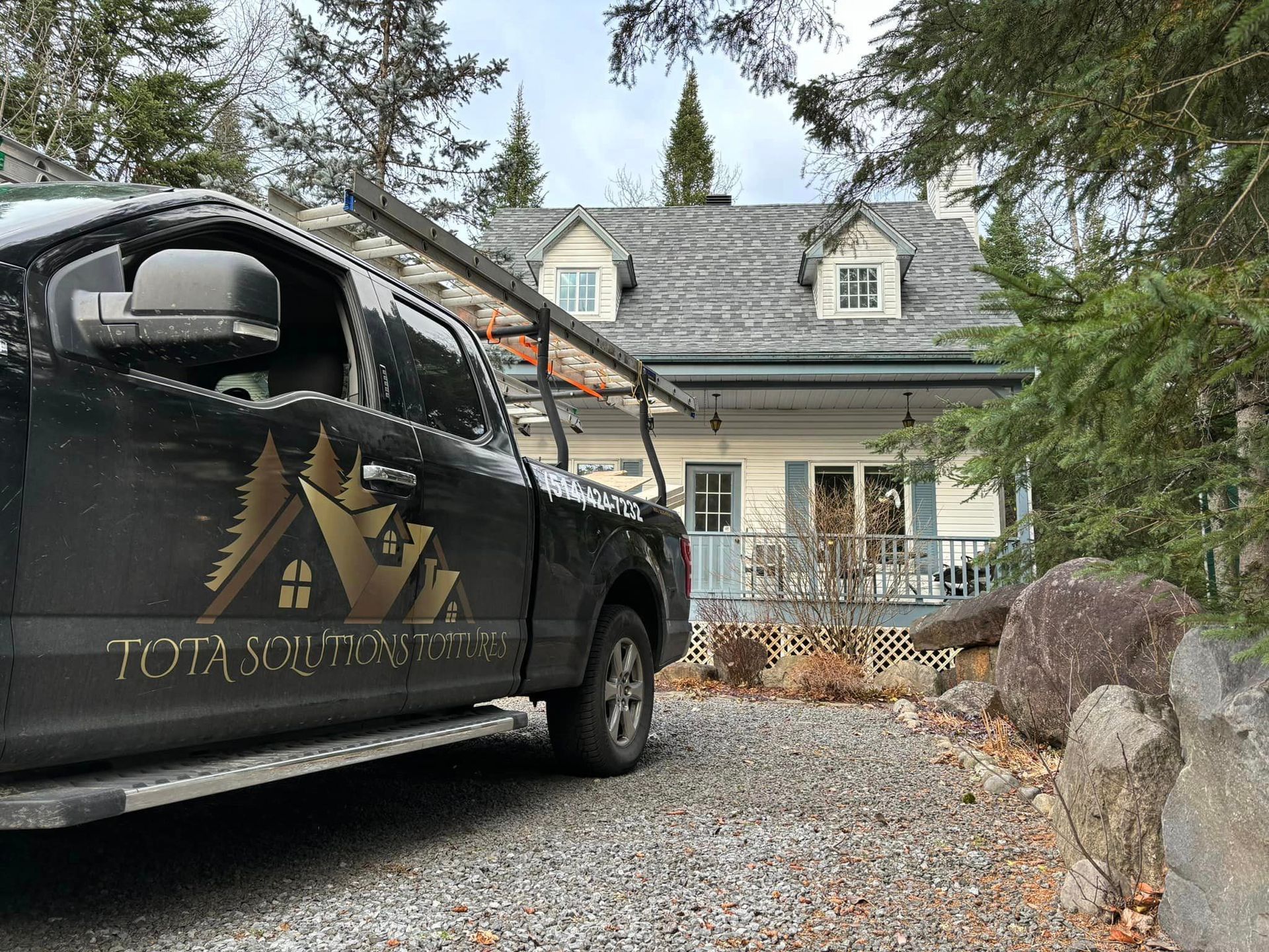 Un camion noir est garé devant une maison.