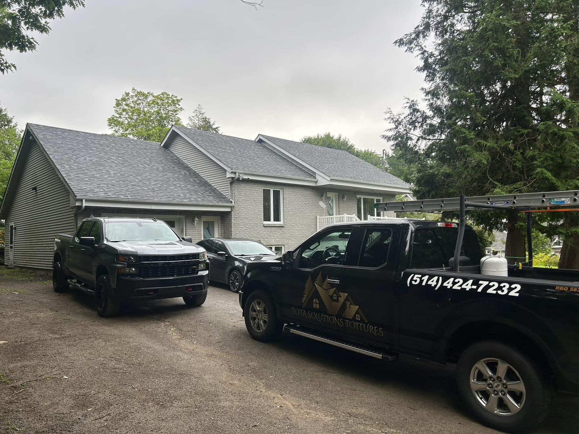 Deux camions sont garés devant une maison.