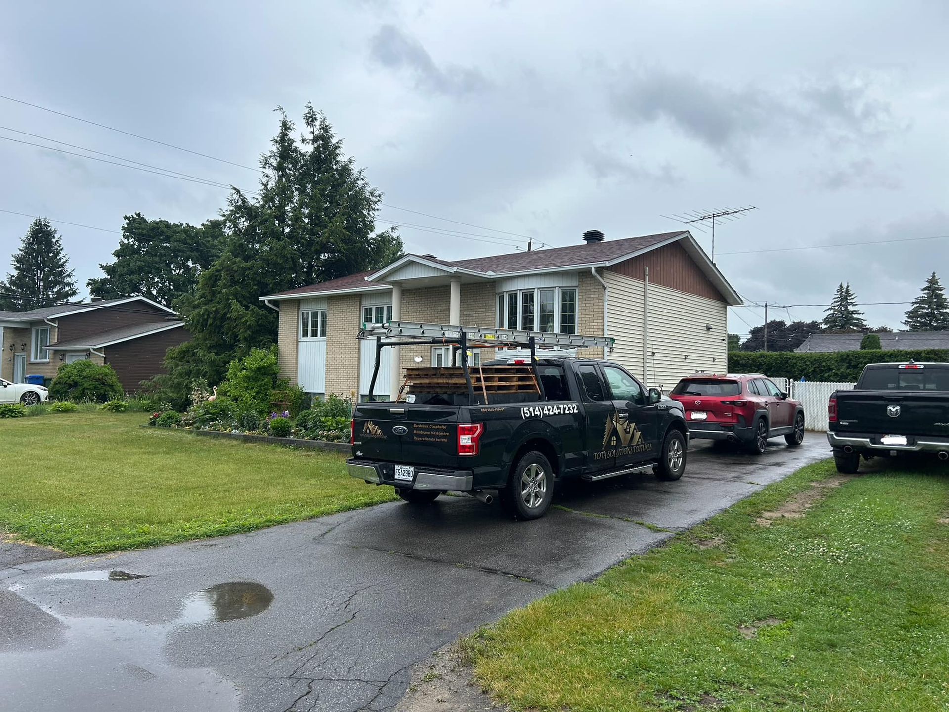 Un camion est garé devant une maison un jour de pluie.