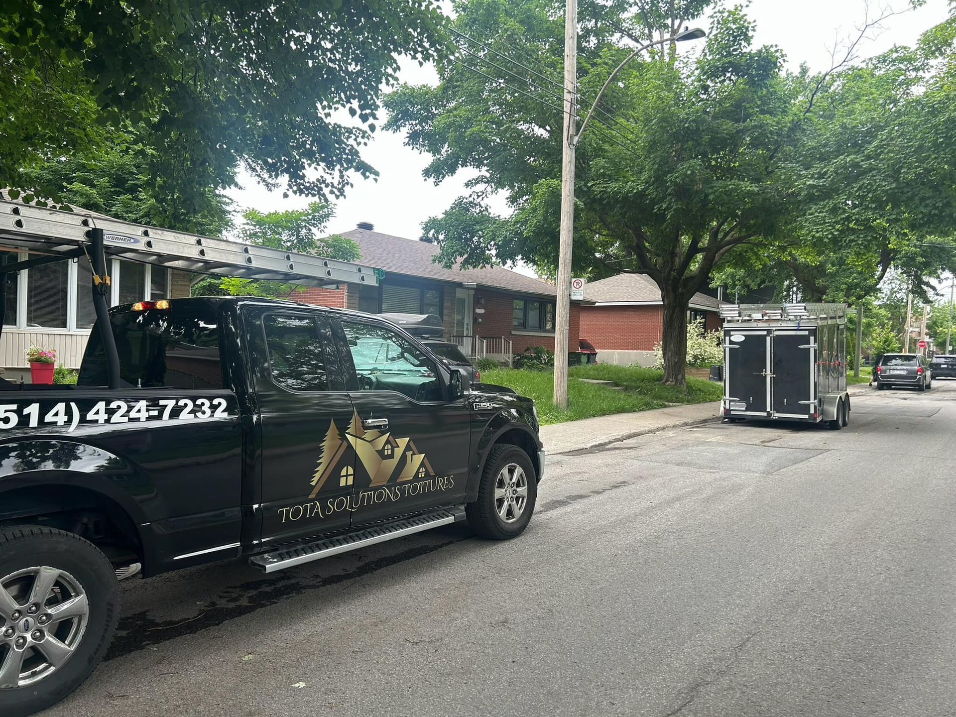 Un camion noir est garé sur le bord de la route.