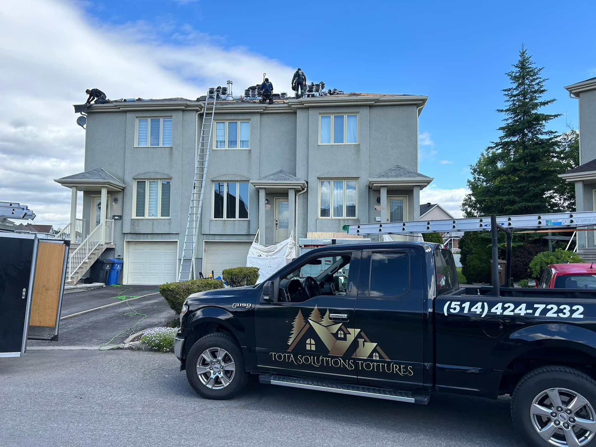 Un camion noir est garé devant une maison.