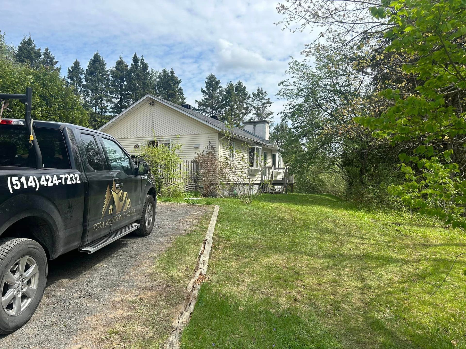 Un camion noir est garé devant une maison.