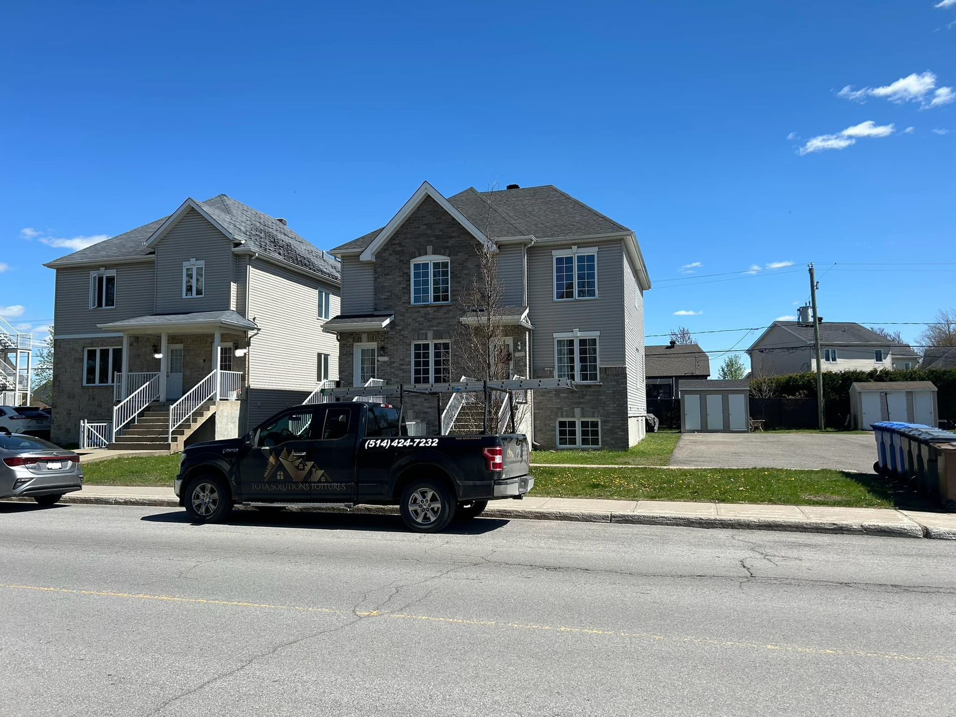 Un camion est garé sur le bord de la route devant une maison.