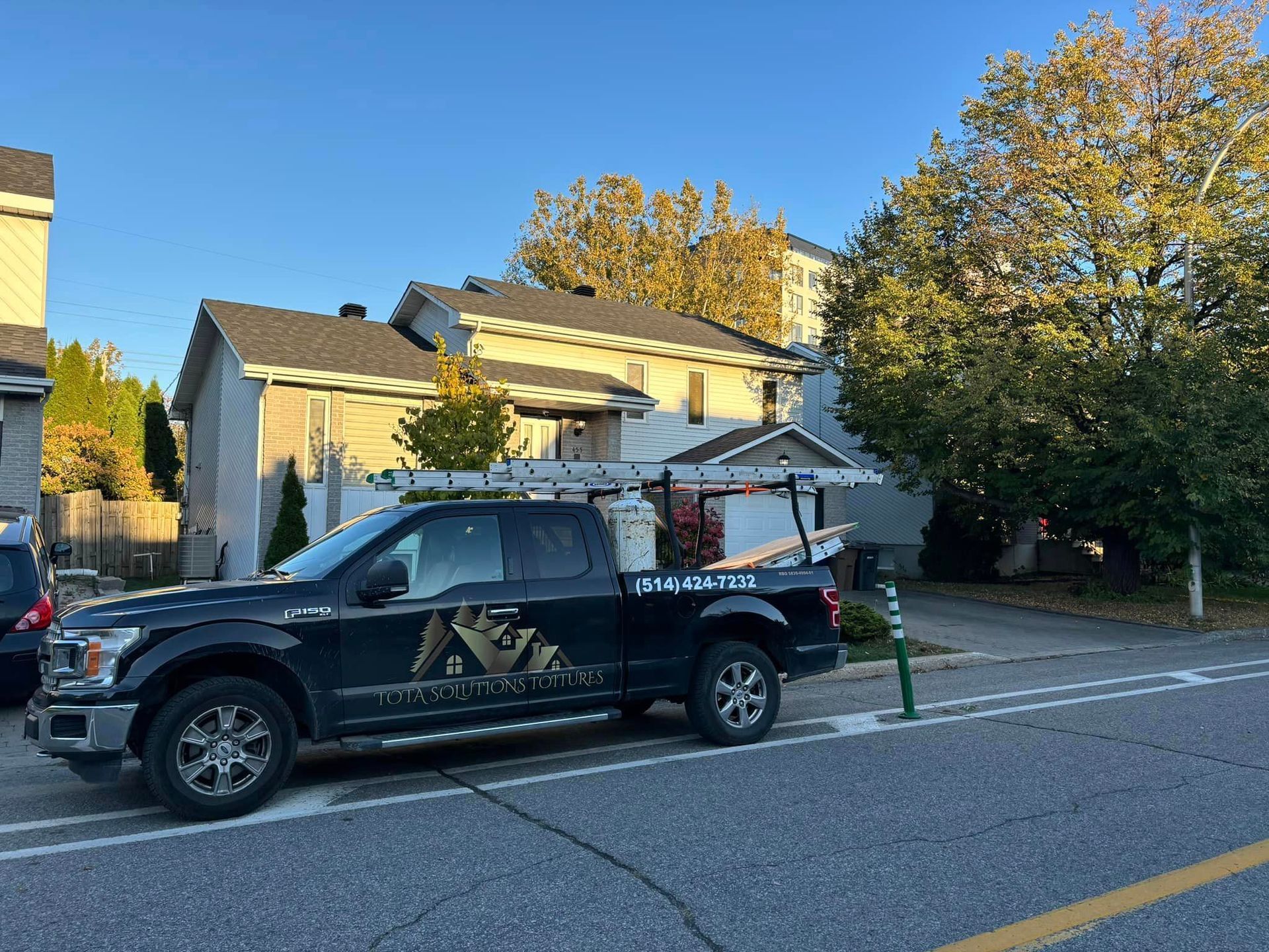 Un camion est garé sur le bord de la route devant une maison.