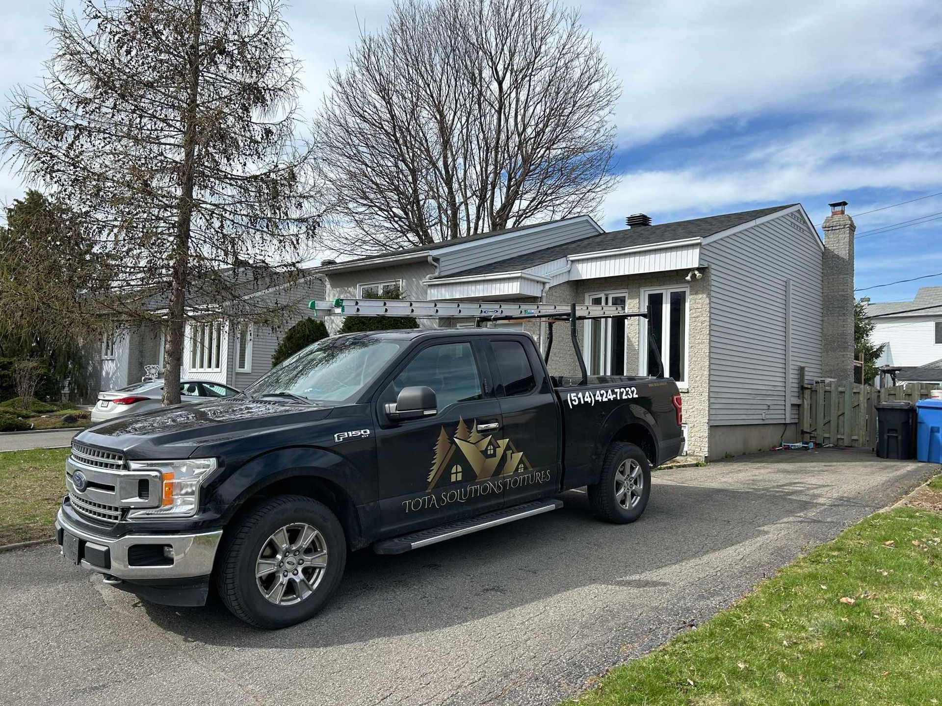 Un camion noir est garé devant une maison.