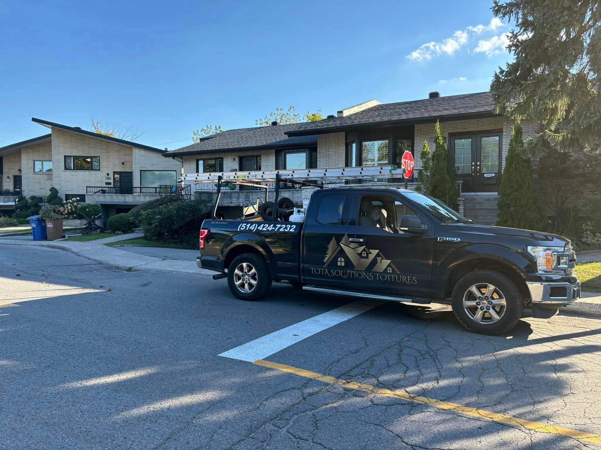 Un camion noir est garé devant une maison.