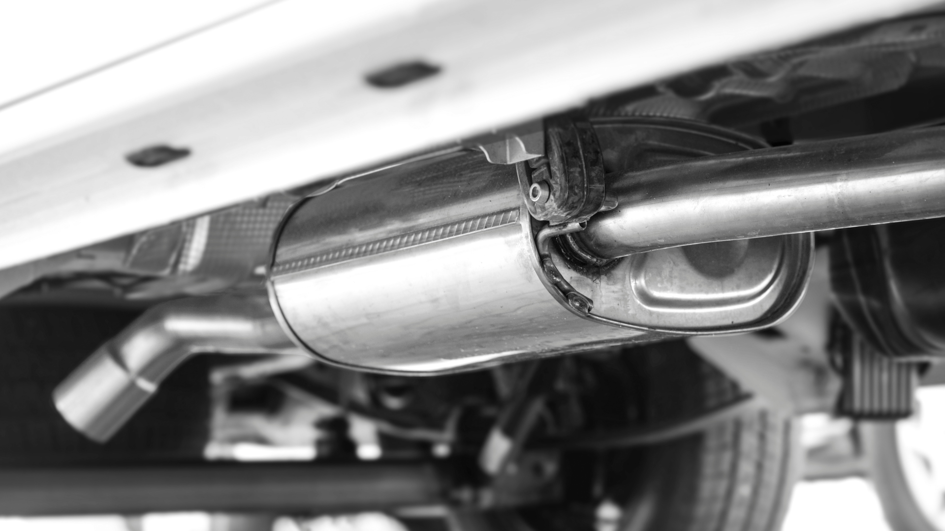 A close up of a exhaust pipe on the underside of a car.