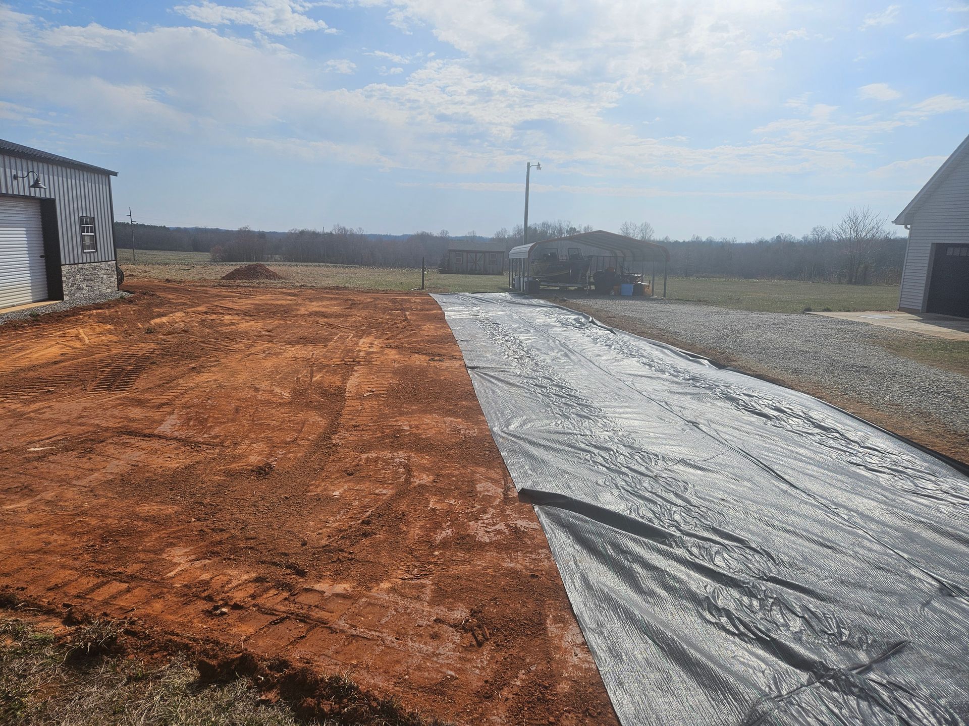 A large piece of plastic is covering a dirt road.