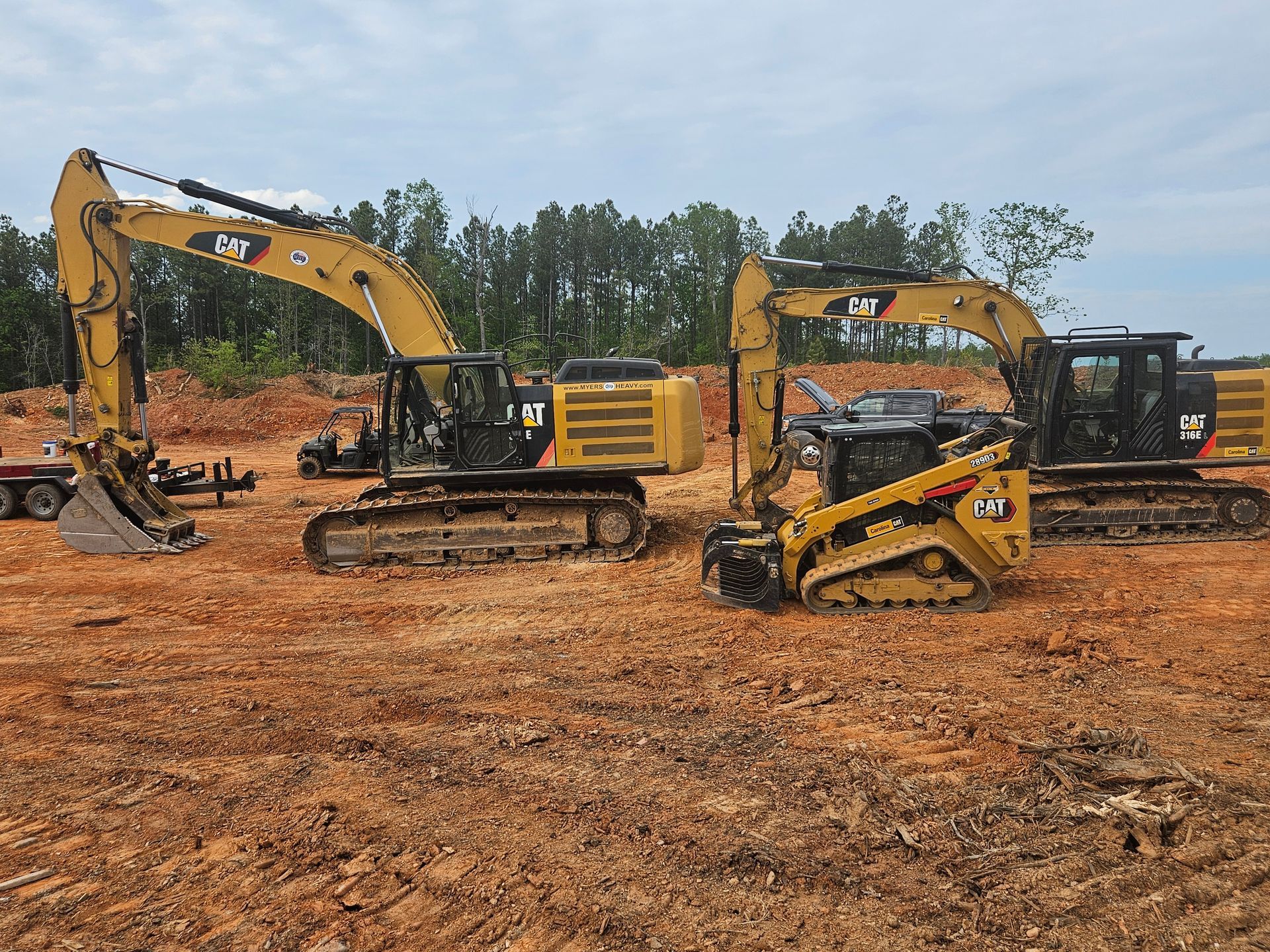 Three construction vehicles for Alexander Excavating working on building site prep for construction project 