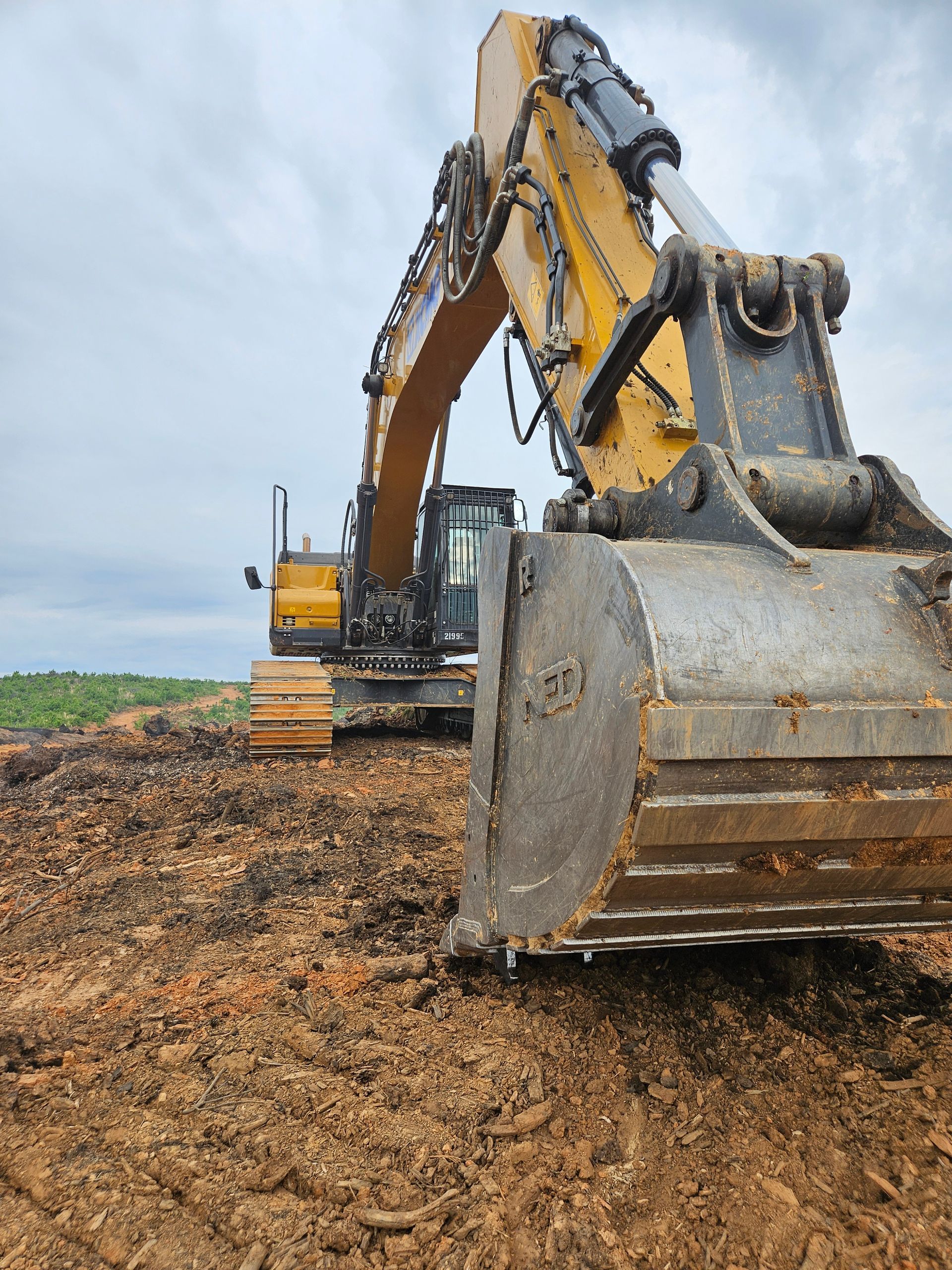 A large excavator is sitting on top of a pile of dirt.