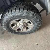 Close-up of a truck tire, showing the tread and a silver wheel.