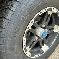 Close-up of a trailer tire and wheel with black spokes and silver accents.
