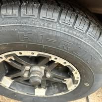 Close-up of a black tire with silver rim and the word 