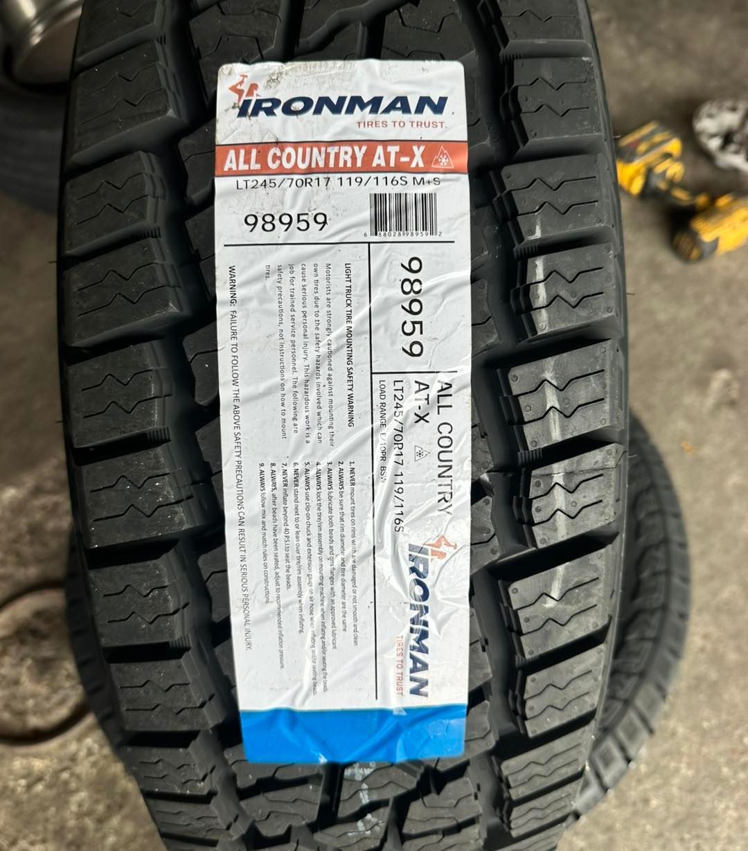 New Ironman All Country AT-X tire with sticker attached, showing the tire model and specifications.