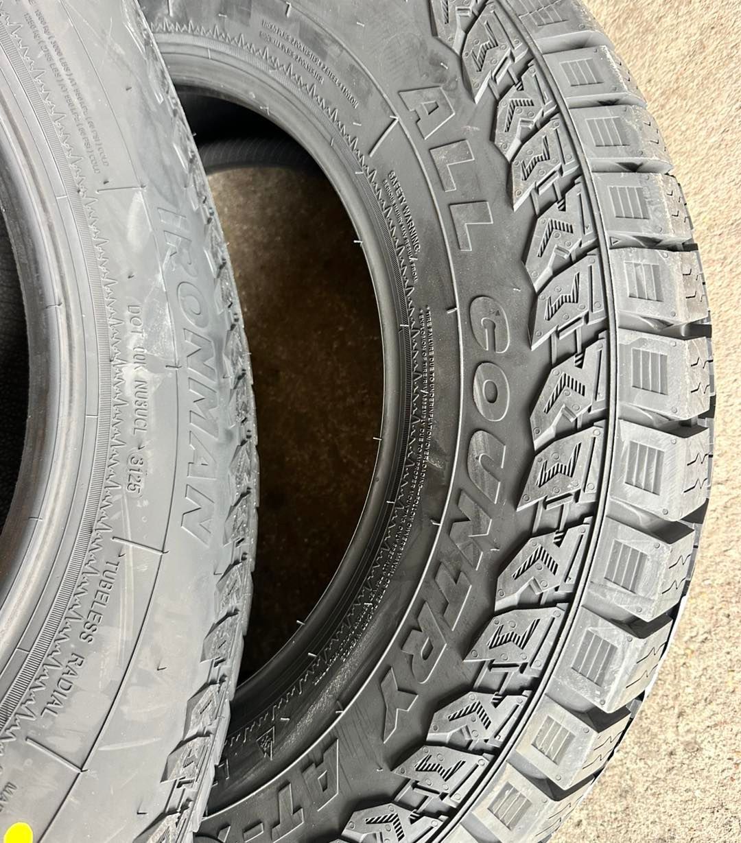 Two black Goodyear Wrangler All-Terrain tires with tread patterns, side by side.